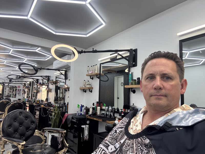 Paul getting his hair cut at King Caesar's barber shop